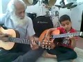 Dziadek z wnuczkiem grają na gitarze