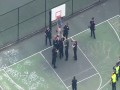 Policjanci próbują sciągnąć naćpanego faceta, który wlazł na kosz